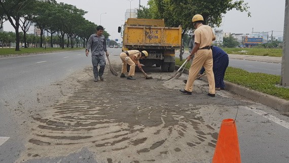 執勤交警同民眾用鏟子和掃把積極清理路面的泥土。