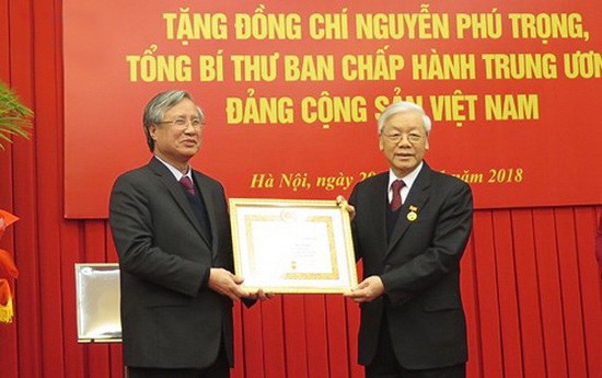 阮富仲總書記(右)榮獲 50 年黨齡紀念章。（圖源：VOV）