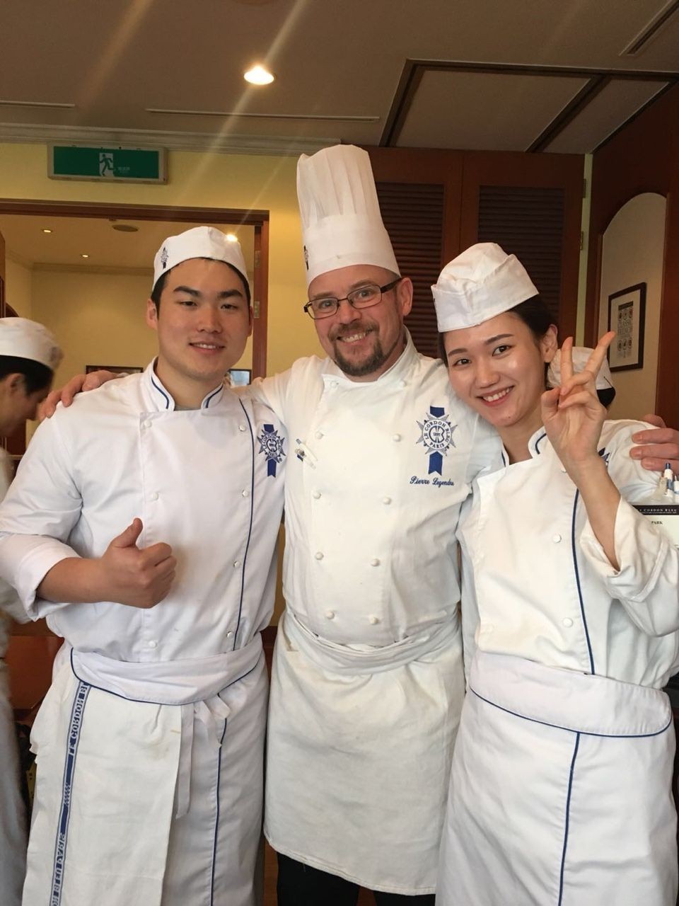 符國焌（左）和朴智善（右）與韓國藍帶國際 學院的烘焙師合影。