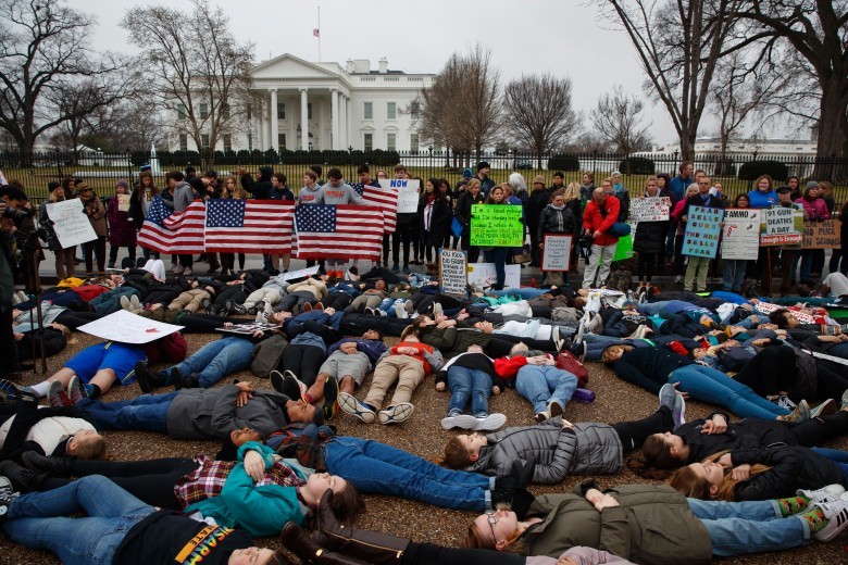 學生躺臥在白宮前的行人路抗議。（圖源：AP）