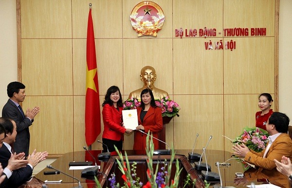 勞動與榮軍社會部副部長陶紅蘭(中左)向阮翠姮同志頒授《家庭與少兒雜誌》副總編輯職務的委任《決定》。