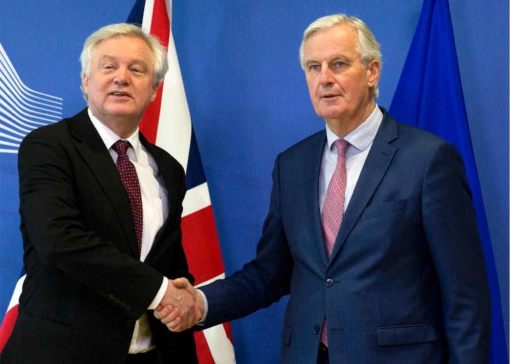 英“脫歐”事務大臣戴維斯（左）與歐盟首席“脫歐”談判官代表巴尼耶握手。（圖源：新華網）