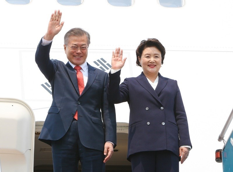 昨(22)日下午，在內牌國際機場，韓國總統文在寅（左）與夫人向接機人員招手。（圖源：陽江）