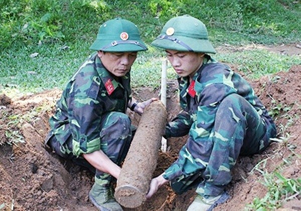 2名工兵將戰後遺留的老炮彈搬移現場。（示意圖源：互聯網）