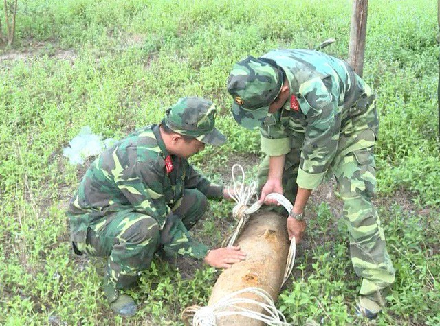 永隆省軍事指揮部的兩名工兵在現場處理戰後遺留的老炸彈。