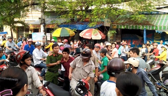 飆車搶劫的歹徒(紅衣)被抓獲引起眾人看熱鬧，導致交通堵塞。（示意圖源：互聯網）