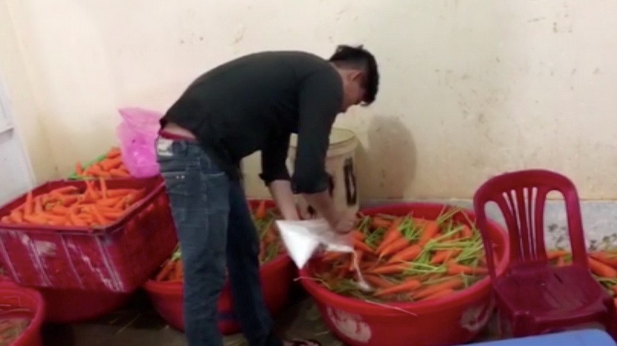 工人正在使用漂白劑放進胡蘿蔔盆裡。（圖源：視頻截圖）