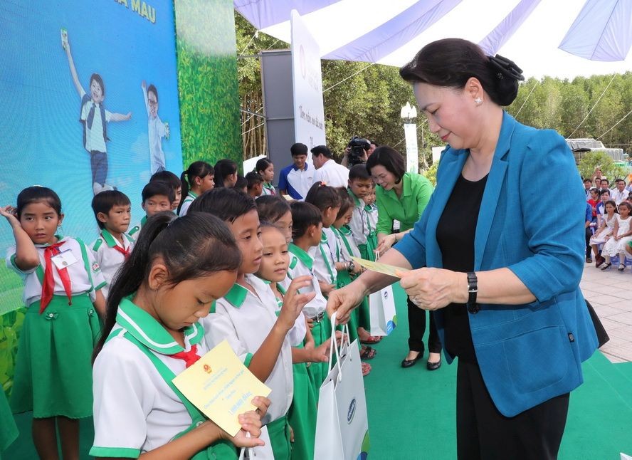 國會主席阮氏金銀向學生贈送牛奶。（圖源：仲德）
