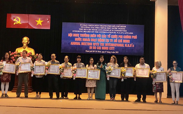 各外國非政府組織代表榮獲胡志明市人委會頒發的獎狀。（圖源：明協）