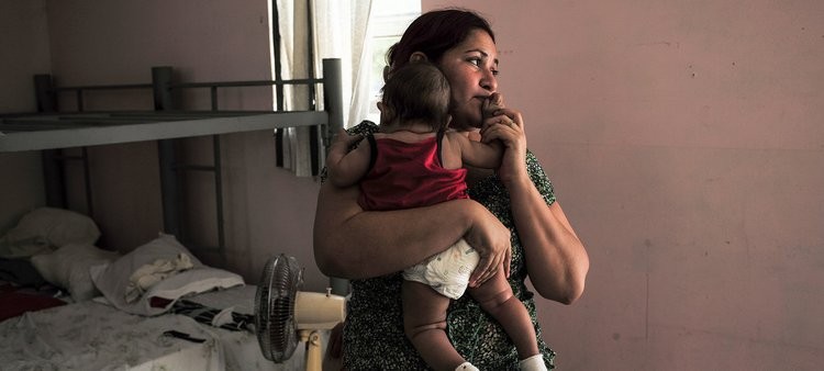 一位移民母親與孩子在庇護所中。 (圖源：AP)
