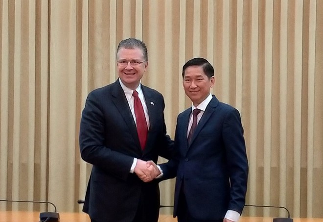 美國駐越南大使丹尼爾‧克里騰布林克與市人委會副主席陳永線握手合照。（圖源：之梅）