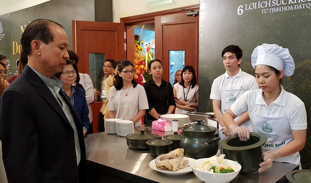 李玉明總經理(左一)指引廚師用瓷鍋煮食品 給來賓品嚐。