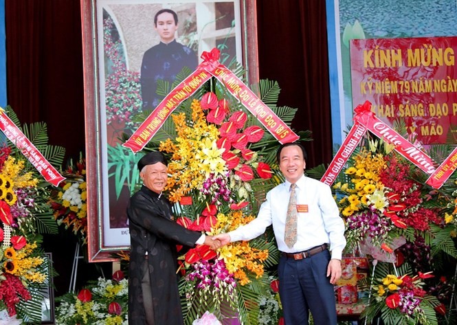 吳策實同志(右)代表越南祖國陣線中央委員會向和好佛教教會中央理事長贈送鮮花祝賀。（圖源：國忠）