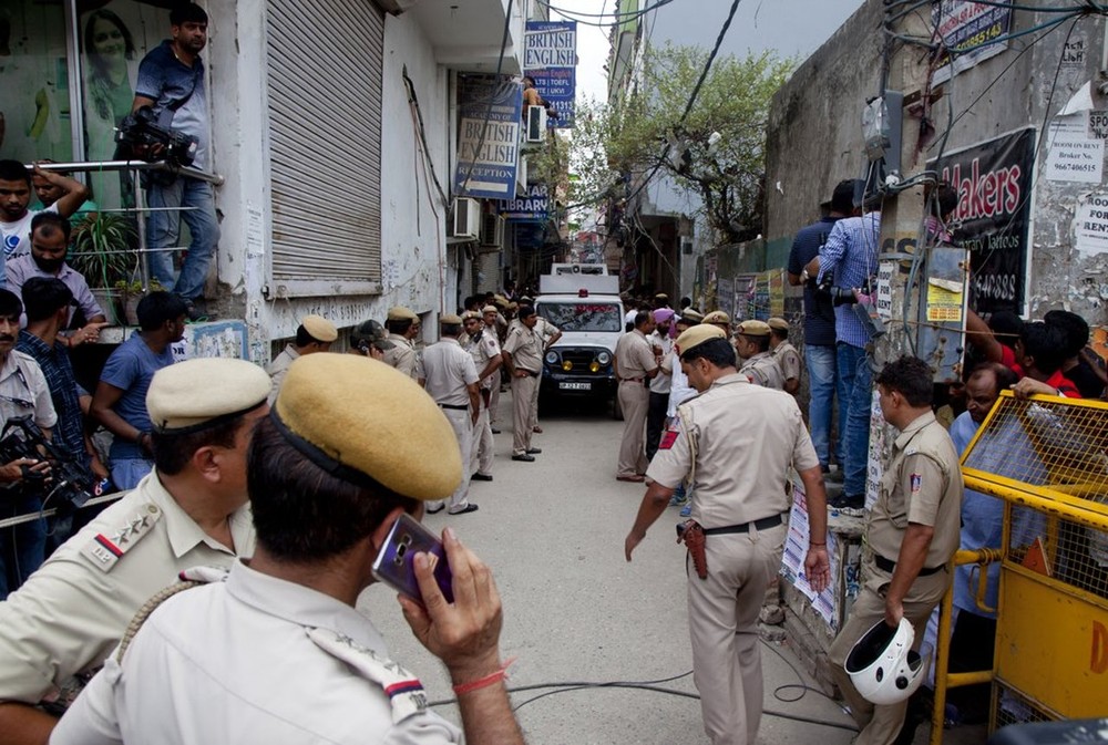 印度11屍倫常命案：案件在7月1日揭發後，警員接報抵達位於新德里布拉里的案發現場樓下。（圖源：路透社）