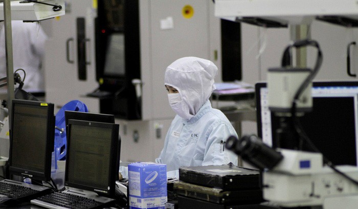一名工人在新加坡某一微芯片製造廠監控生產過程。（圖源：路透社）