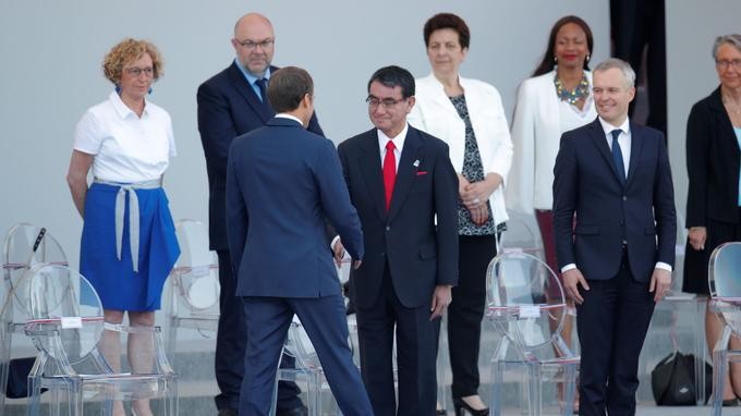 法國總統馬克龍與前來出席國慶閱兵儀式的日本外務大臣河野太郎（前排中）握手。（圖源：路透社）