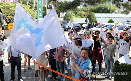 市民揮舞韓半島旗歡迎朝鮮乒乓球代表團來訪。（圖源：韓聯社）