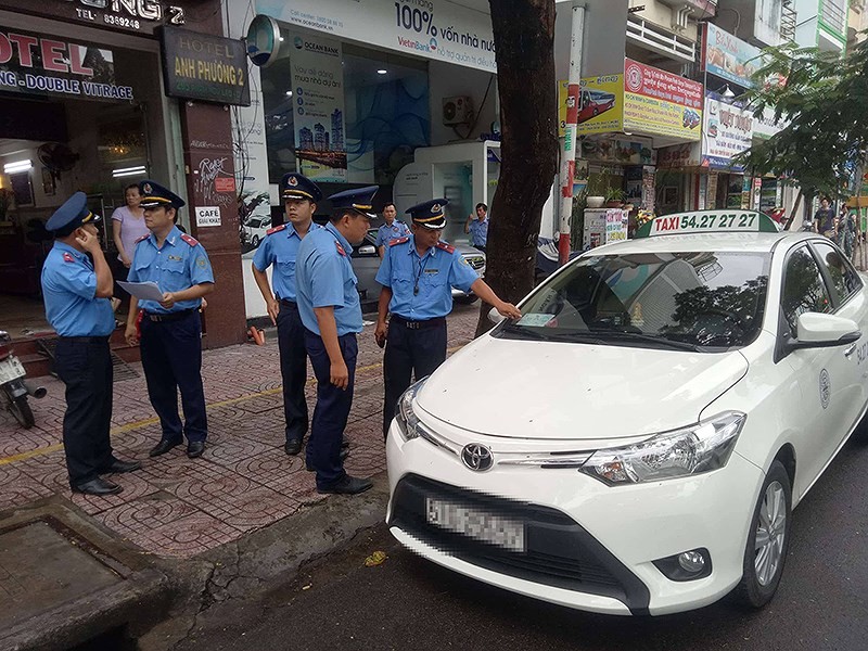 交通監察員在處理一起違規的“野雞”計程車。（圖源：N.Tân）