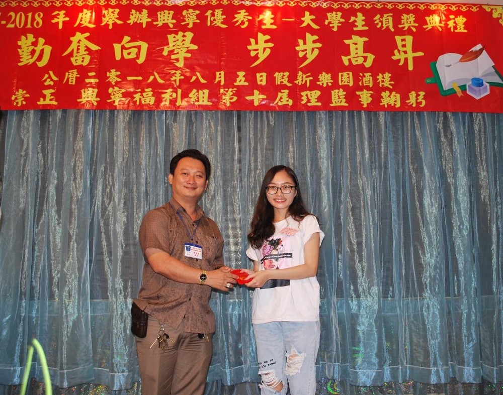 崇正興寧福利組理事長鄒國榮（左一）向曾靜詩模範生頒發獎學金。