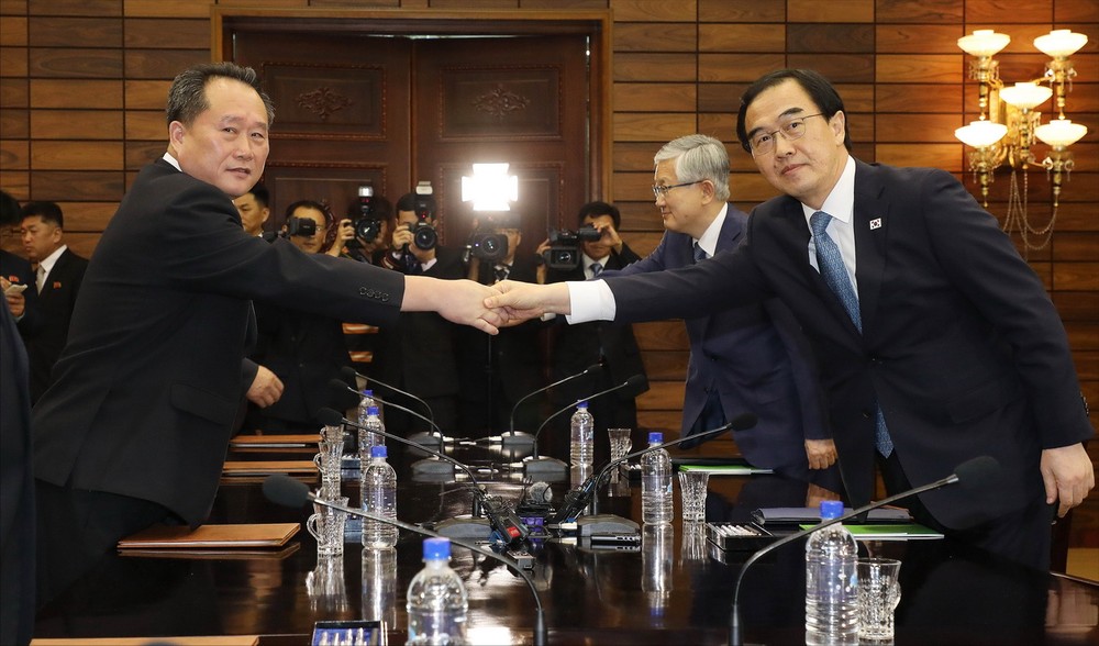 韓統一部長官趙明均（右）與朝祖國和平統一委員會委員長李善權握手合影。（圖源：新華網）