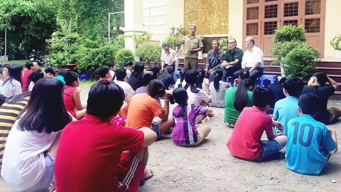 阮光中（站）與第一街區退伍軍人分會的會員向年輕人講述傳統的故事。