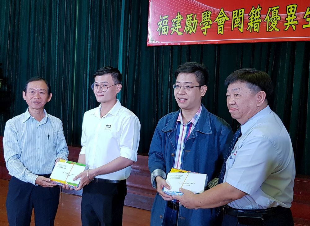 市民族處副主任梁鴻德(左一)與溫陵會館 理事長張子諒(右一)頒發獎學金給碩士畢業生。