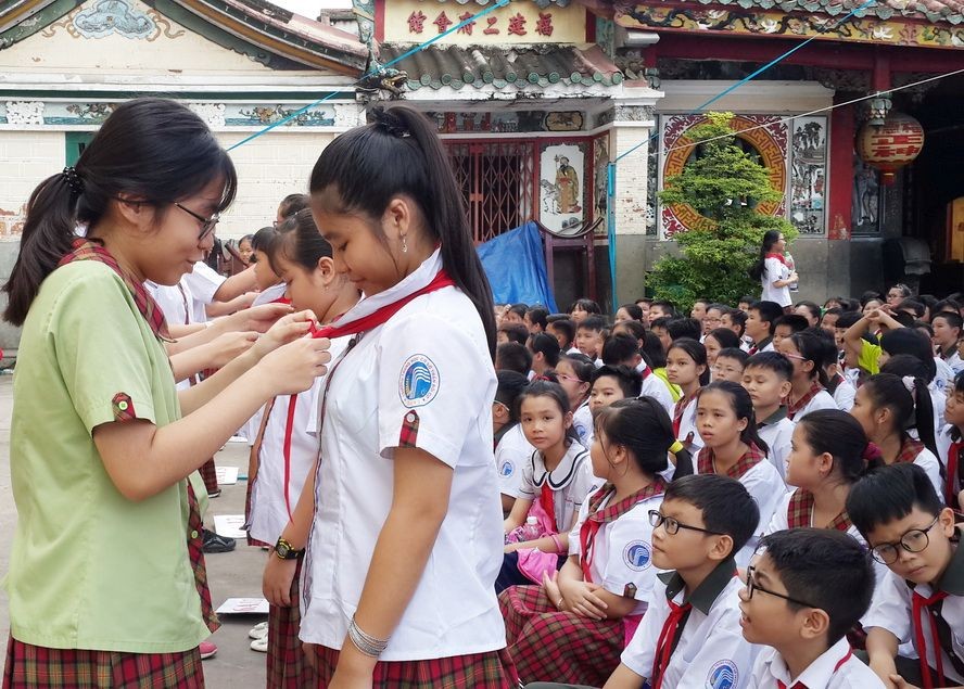 陳佩姬學校九年級學生向六年級新生轉交紅領巾。