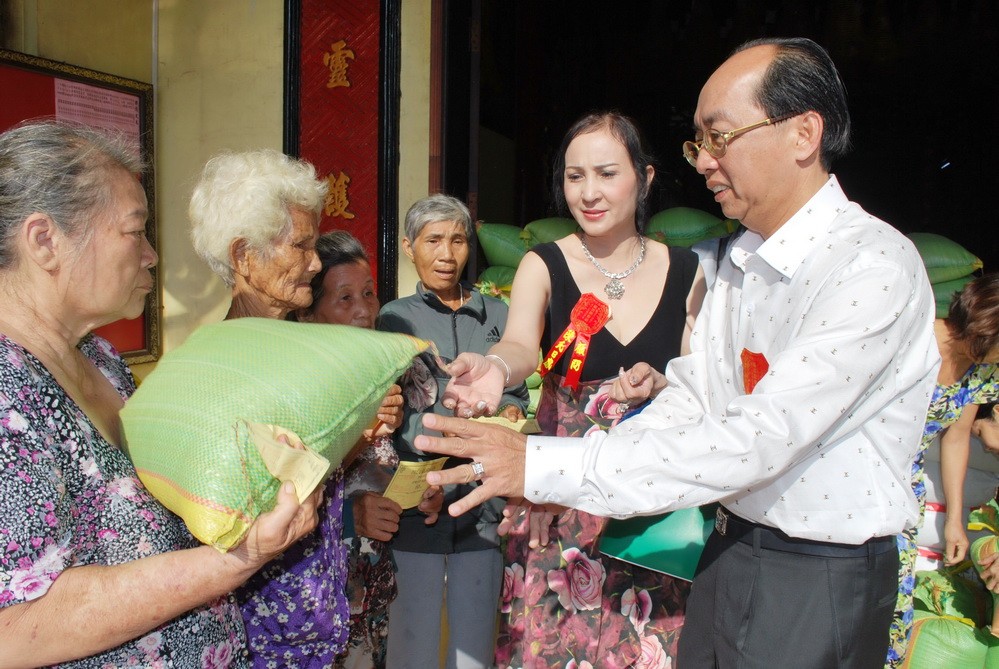 理事長黃偉峰和夫人阮氏日鳳向窮人派發大米。