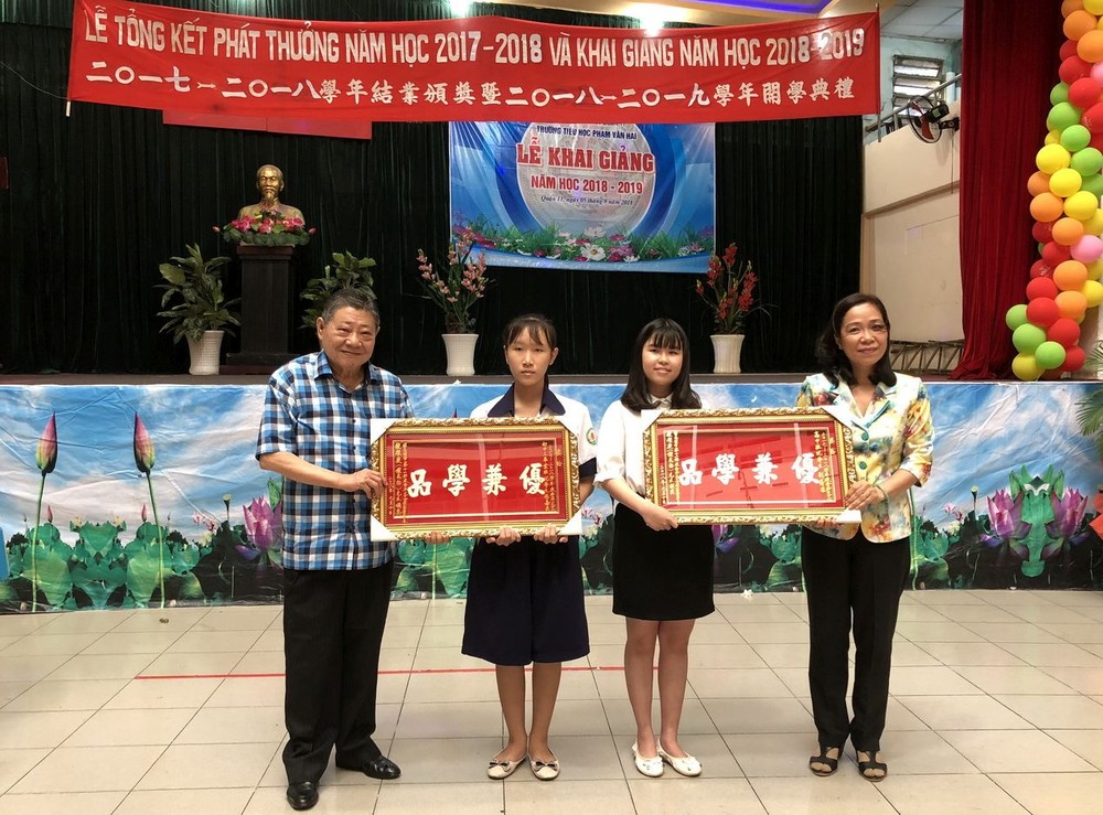 杭慰瑤董事長(左一)頒獎牌給品學兼優的學生。 