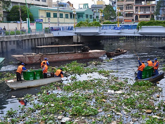 清潔工人正在河涌上打撈垃圾。