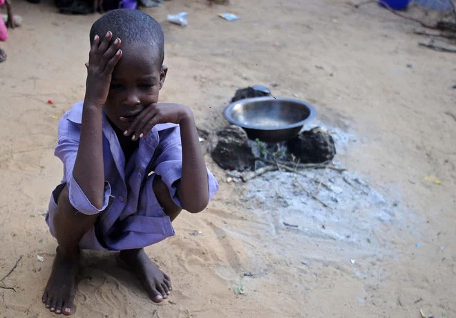 在索馬里首都摩加迪沙郊外的難民營，一個孩子蹲坐在地。（圖源：Getty Images）
