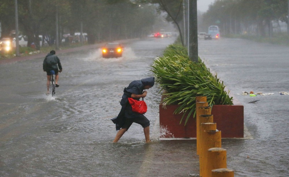 菲律賓民眾頂著狂風暴雨出行。（圖源：AP）