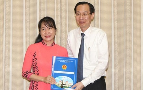 市人委會常務副主席黎清廉（右）向周雲海同志頒發科學與技術廳副廳長職務委任《決定》。