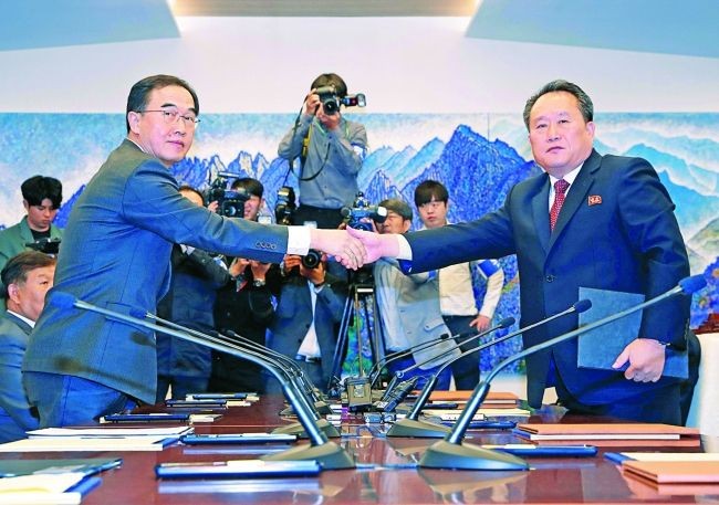 韓方代表團團長趙明均與朝鮮代表團團長李善權在會談前握手。（圖源：路透社）