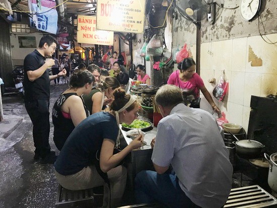 導遊向外國遊客介紹河內市同春街市小食。