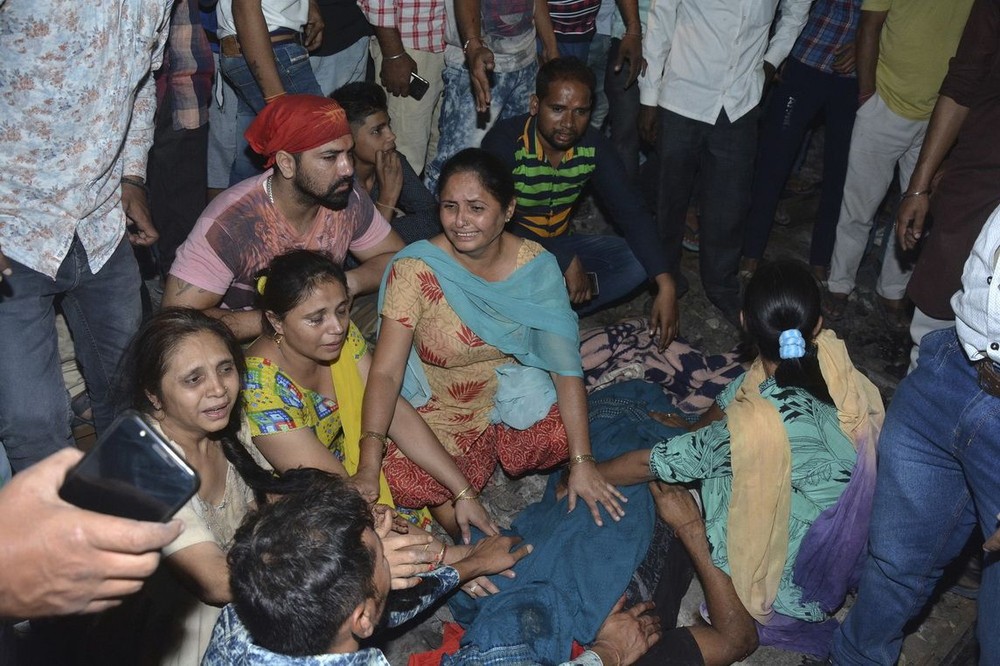 10月19日，在印度旁遮普邦首府阿姆利則附近，遇難者的親屬在遺體旁哭泣。（圖源：AP）