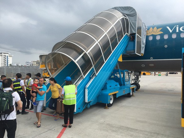 由於發生技術故障，乘坐VN117航班的乘客要下機返回機場候機廳。（圖源：D.Tuấn）