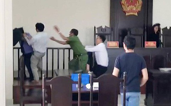 視頻錄下的畫面：阮文賢衝上法台前揮拳擊打檢察員。（圖源：視頻截圖）