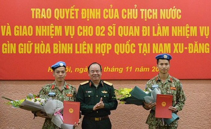 越南人民軍隊副總參謀長范玉明上將（中）向陳德享少校和阮福東大尉轉交國家主席的《決定》。（圖源：黃宇）