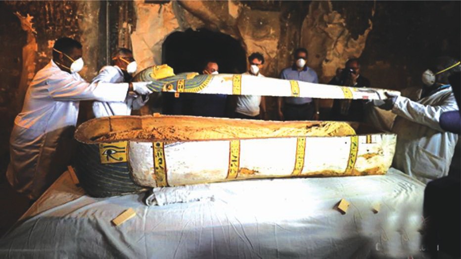 11月24日，在埃及盧克索省，工作人員在墓室內打開一口裝有木乃伊的棺材。（圖源：互聯網）