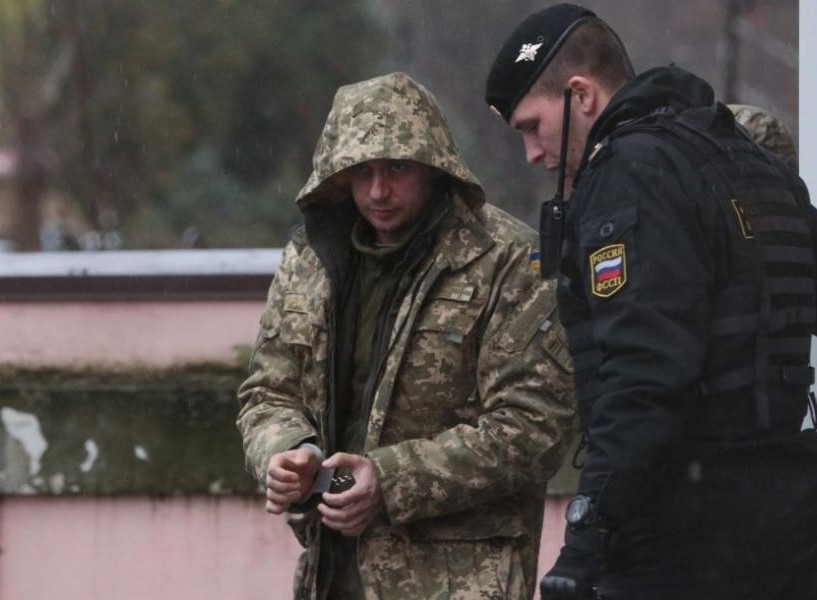 28日，在克里米亞辛菲羅波爾，一名烏克蘭人（左）在警衛護送下離開法庭。（圖源：AFP）