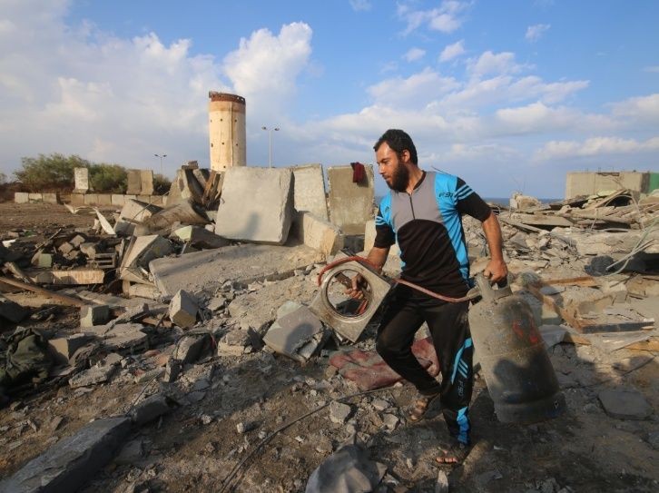 一名巴勒斯坦男子在加沙地帶城市拉法檢查空襲後的 廢墟。（圖源：新華社）