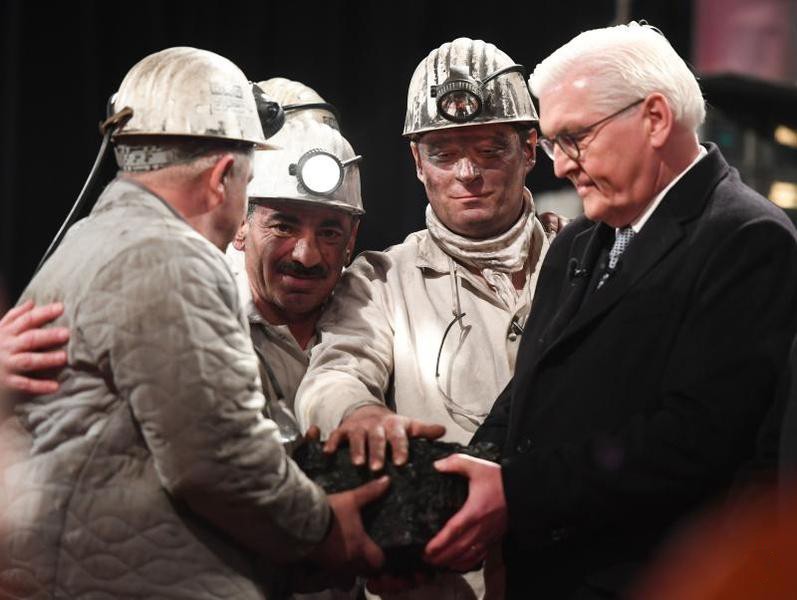 煤礦工人在現場象徵性地挖出最後一塊硬煤，交到德國總統施泰因邁爾（右）手中。 （圖源：AFP）
