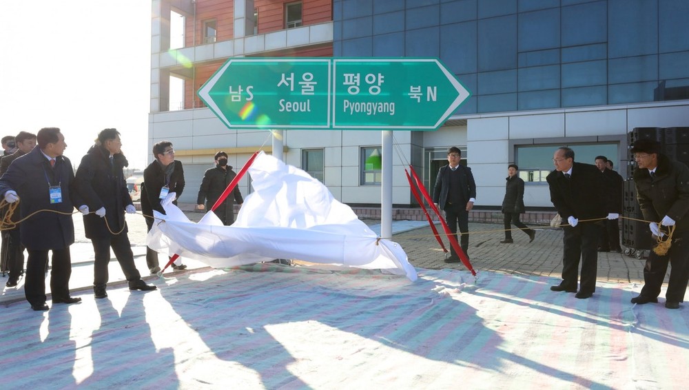 朝鮮和韓國代表團26日在朝鮮開城板門火車站舉行朝韓鐵路和公路對接項目開工儀式。圖為雙方為路牌揭幕。（圖源：路透社）