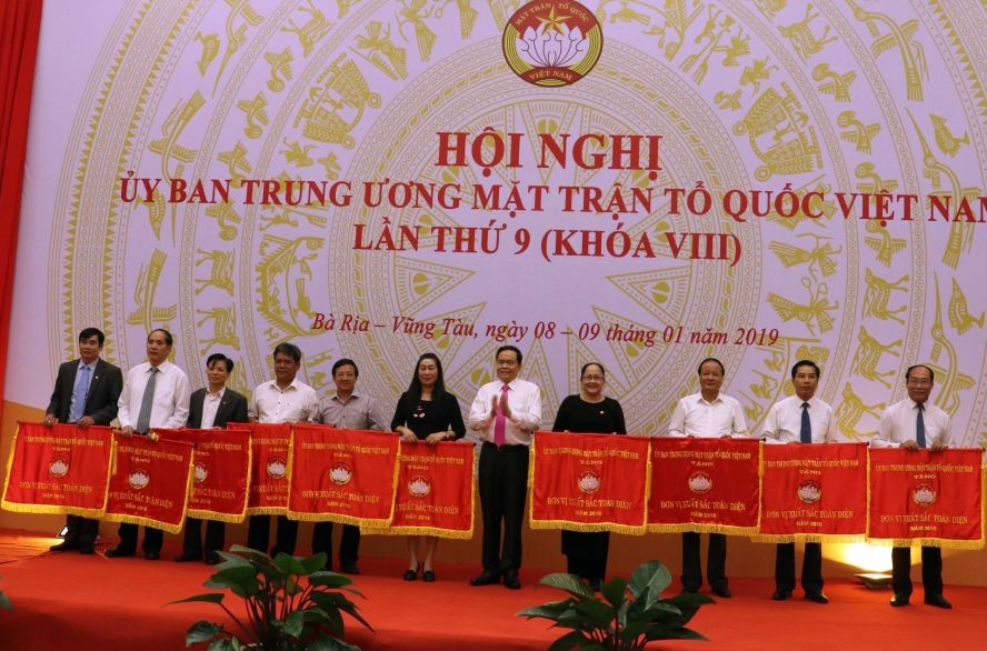 越南祖國陣線中央委員會主席陳清敏（右五）向2018年對陣線工作有重大貢獻的各成員組織頒發出色錦旗。（圖源：越通社）