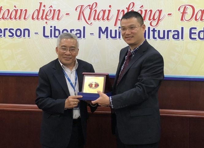 市人文社科大學副校長黎友福（左）向廣西財經學院團代表贈送紀念品。