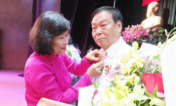 市委組織處副主任阮氏蘇珠向高齡黨員頒授黨齡紀念章。（圖源：蔡芳）