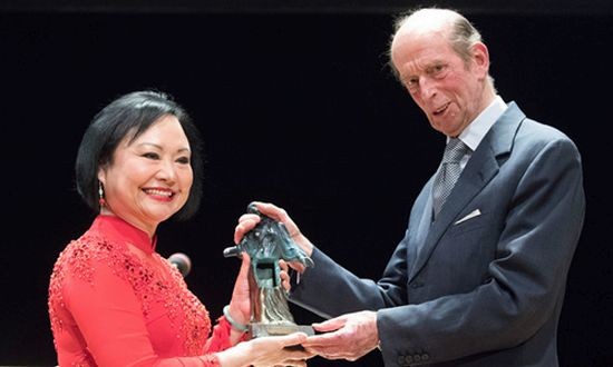 潘金福（左）在德國德勒斯登市森柏歌劇院舉行的頒獎禮上，從肯特公爵愛德華王子手中接過獎座。（圖源：AFP）