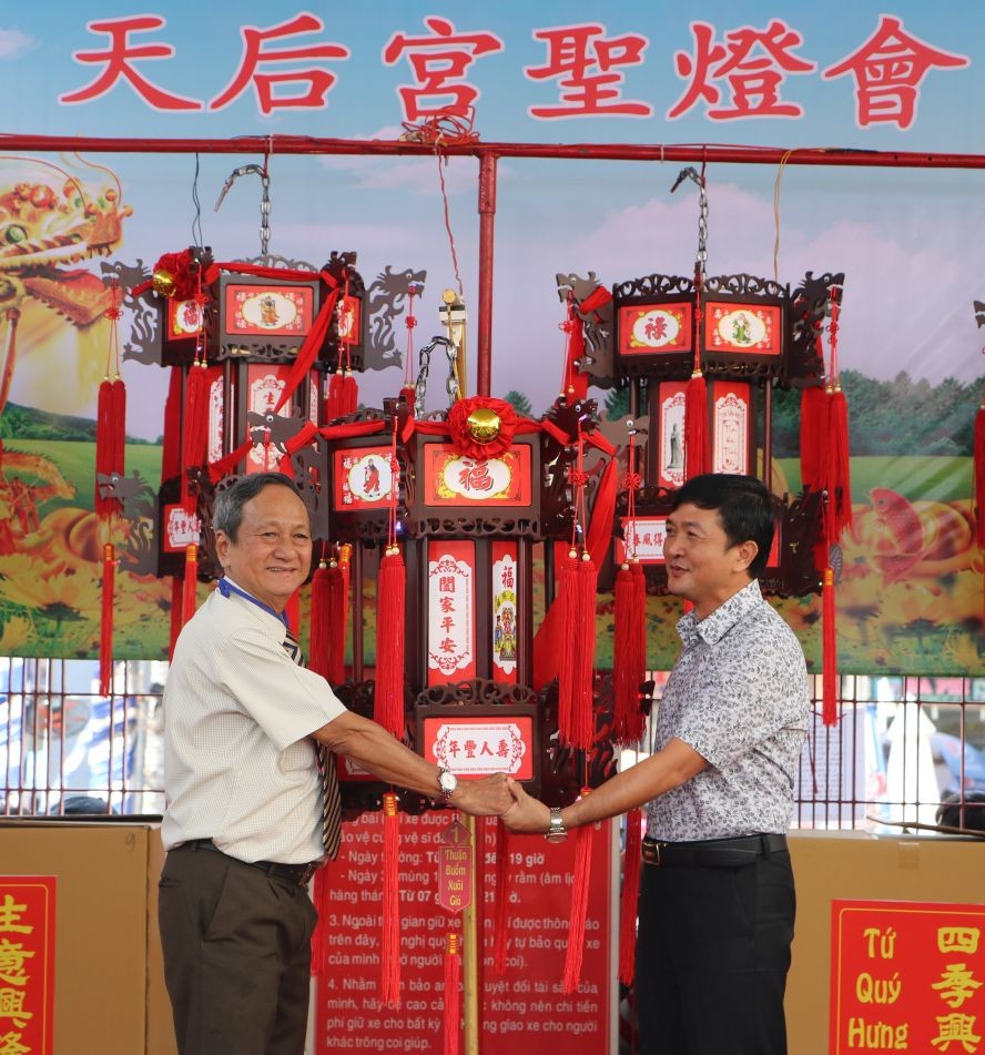 王永勝理事長（左）向平陽玉田房地產公司代表移交“一帆風順”聖燈。