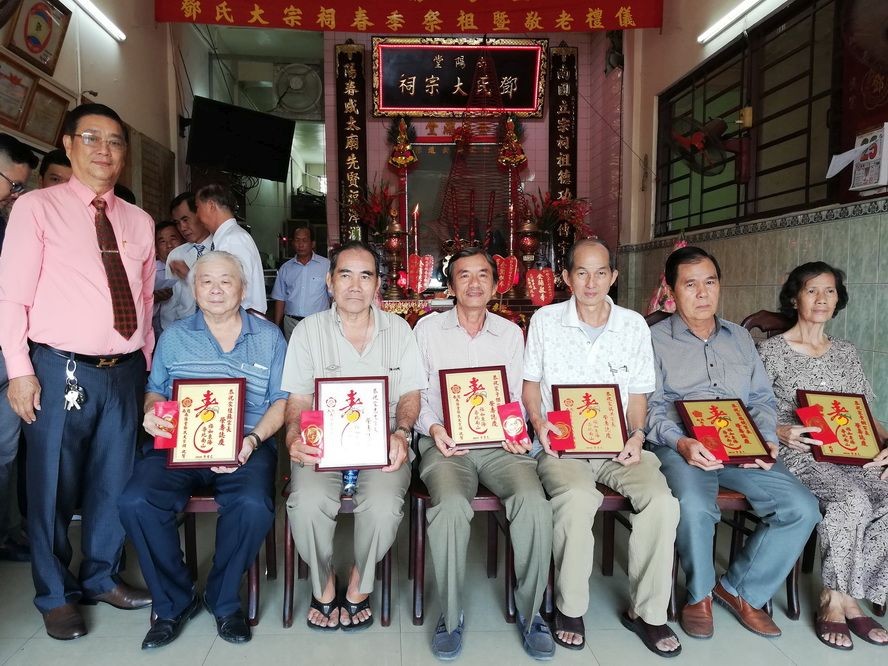 理事長鄧柏榮（左）向各宗親長老敬送祝壽利是合照。